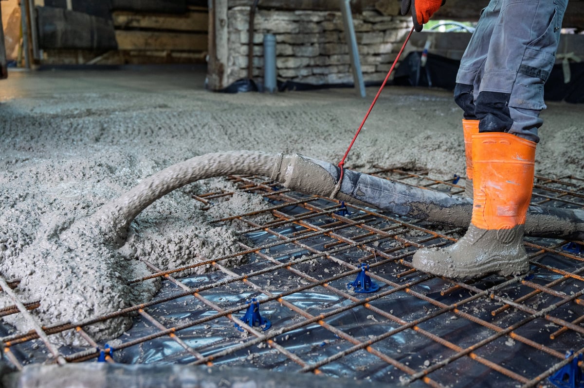 Worker pouring concrete for a building foundation