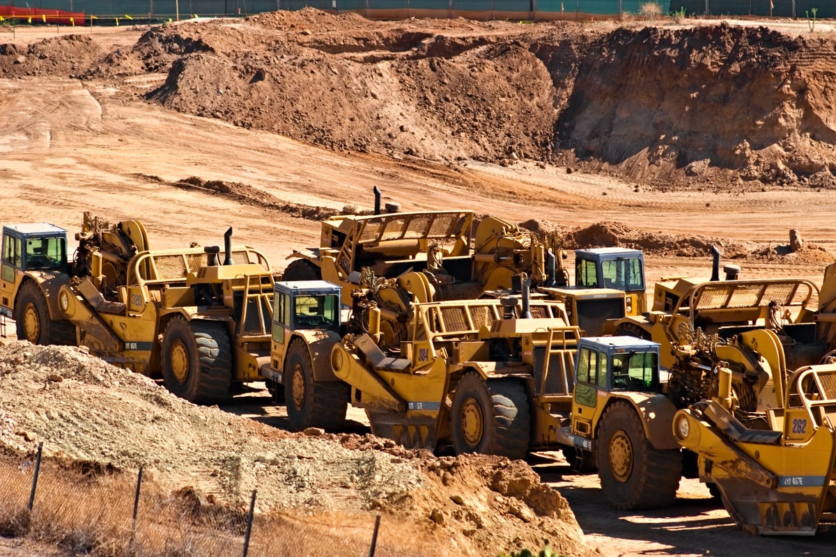 Heavy equipment resting at a construction site under bright sunlight
